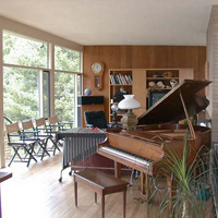 The living room looking right, taken from the kitchen doorway. We tried to sell our piano before we moved here, thinking that it wouldn't fit, but fortunately no one bought it and it fits just fine.  That's a set of vibes in the middle. The cabinets for the stereo/TV were in our den in Wellesley; they fit much better here.