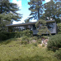The house is T-shaped, with the bedrooms, baths, office, and studio in the wing out the back. The front (above) faces the pond, due south. The overhang is such that practically no sun gets into the house in the summer (you can see where the shadow falls) but tons of sun gets in during the winter. The kitchen's on the right of this pic, LR/DR on the left.